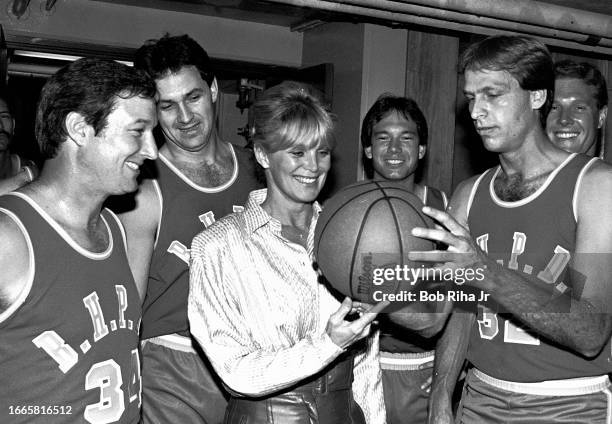 Actress Linda Evans with Beverly Hills Police Officers before a charity basketball game against Hollywood Celebrities, February 28, 1985 in Beverly...