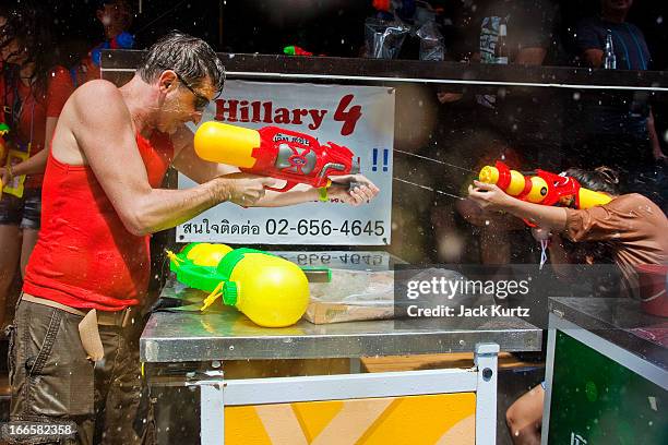 Tourists shoots a squirt gun into a bar on Soi Nana during the Songkran water festival on April 14, 2013 in Bangkok, Thailand. The Songkran festival...