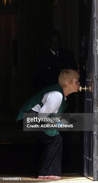 Downing Street employee breathes on the door to polish it ahead of the arrival of US President Barack Obama at 10 Downing Street in London, on May...