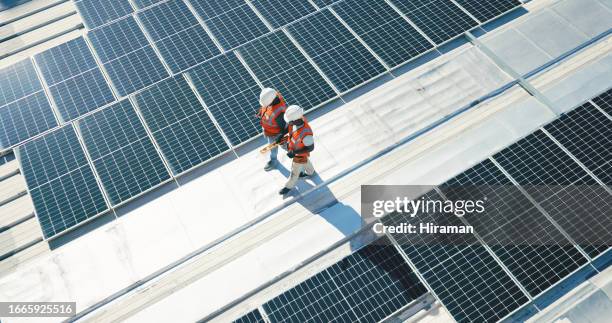 energía renovable, paneles solares y equipo caminando en la planificación del techo para la inspección en negocios sostenibles. ingeniería, sostenibilidad y energía fotovoltaica, hombres en el mantenimiento de electricidad desde arriba. - solar green energy fotografías e imágenes de stock