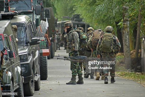 Indian army soldiers carry ammunitions as they move towards the gun-battle site which entered second day in Gadole village of Kokernag in Anantnag...