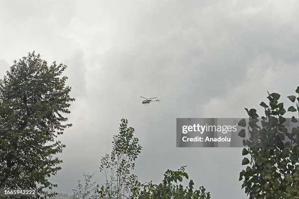 An Indian army chopper hovers during the gun-battle between militants and security forces which entered second day in Gadole village of Kokernag in...