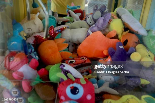 toy stuffed animals inside a claw machine used as prizes - arcade machine stockfoto's en -beelden