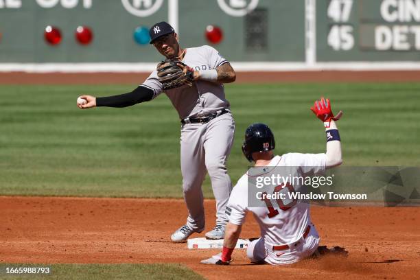 Gleyber Torres of the New York Yankees turns a double play over sliding Trevor Story of the Boston Red Sox during the second inning of game one of a...