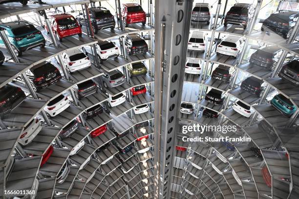Volkswagen cars stand on elevator platforms inside one of the twin towers used as storage at the Autostadt promotional facility next to the...