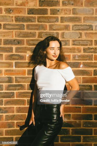 cool portrait of young fashionable lady with brick wall background - modern living bricks stock pictures, royalty-free photos & images