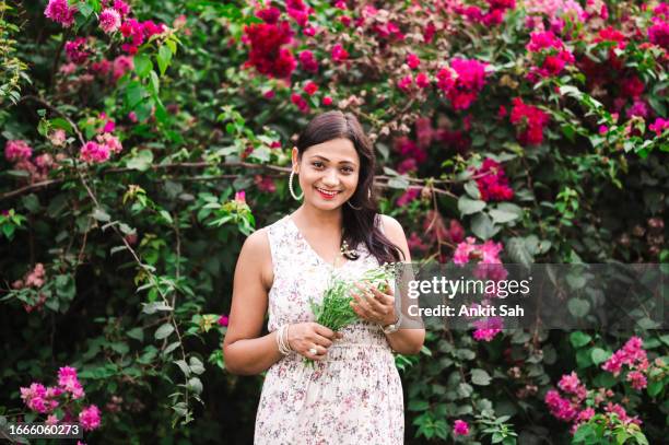 portrait of beautiful asian woman in meadow holding wild flowers - india wild life stock pictures, royalty-free photos & images