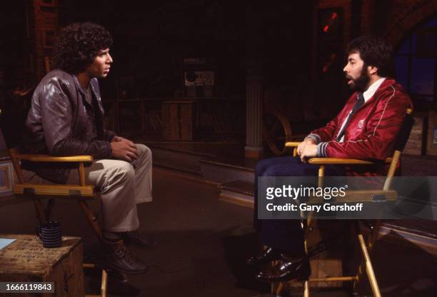 View of MTV VJ Mark Goodman and American computer engineer and programmer Steve Wozniak, co-founder of Apple Computer, as they sit in director chairs...