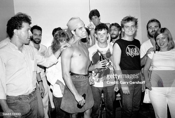 Members of the American Rock group Red Hot Chili Peppers pose with unidentified staff members from their record company, EMI, as they pose backstage...