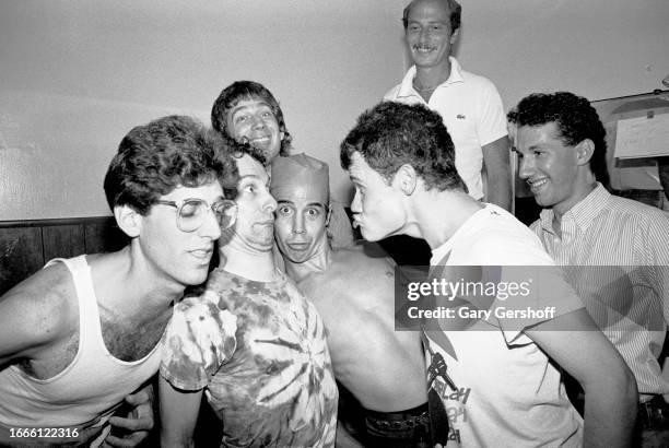 Members of the American Rock group Red Hot Chili Peppers pose with unidentified staff members from their record company, EMI, as they pose backstage...