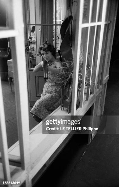 Jacqueline Porel. Paris- Chez elle, Jacqueline POREL, actrice française, assise, visant avec un fusil en joug sur son épaule; prise de vue en...