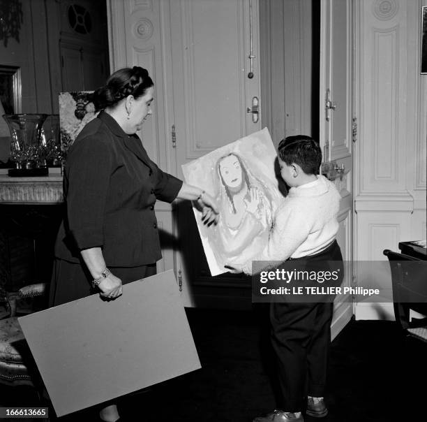 Mrs Rene Coty Receives A Child Painter. Paris- Au palais de l'Elysée, Madame René COTY, épouse du Président, admire une peinture réalisée par un...