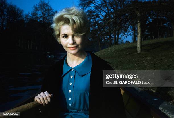 Rendezvous With Noelle Adam. Lors d'une séance de portraits dans un parc, l'actrice Noëlle ADAM en robe bleue et veste noire, assise dans une barque...