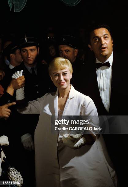 Giulietta Masina, Italian Actress. Portrait de Giulietta MASSINA, actrice italienne, vêtue d'un manteau de satin blanc sur robe rose à strass, tenant...