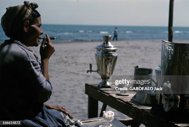 Iranian Caviar Of The Caspian Sea. En Iran, à la fin des années 50, sur une plage de la mer Caspienne, une femme assise de profil près des éléments...