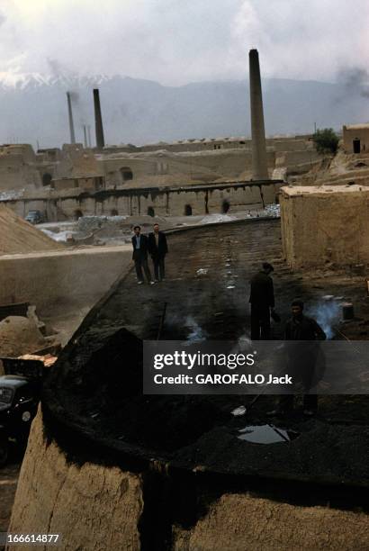 Abadan Refinery In Iran. Abadan - fin des années 50 - Des ouviers travaillant dans une usine avec des cheminées en arrière-plan.