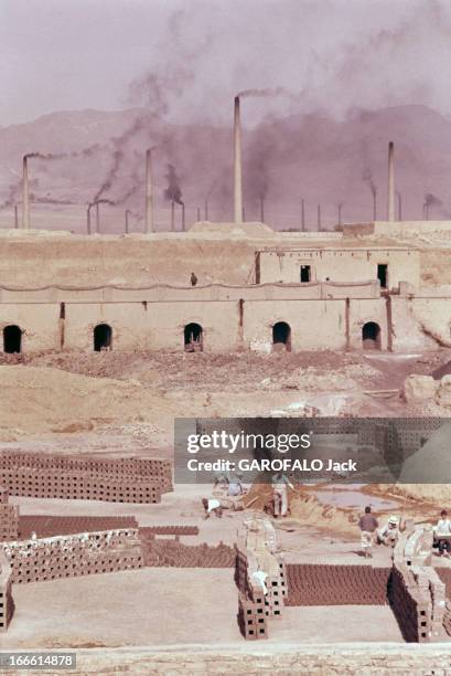 Abadan Refinery In Iran. Abadan - fin des années 50 - Des ouviers fabriquant des briques ou des moellons devant les cheminées et autres installations...
