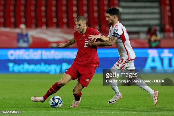 Dominik Szoboszlai of Hungary battles for possession with Strahinja Pavlovic of Serbia during the UEFA EURO 2024 European qualifier match between...