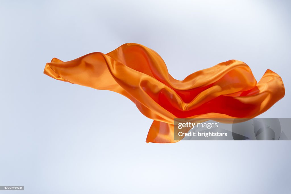 Floating orange silk on a bright background