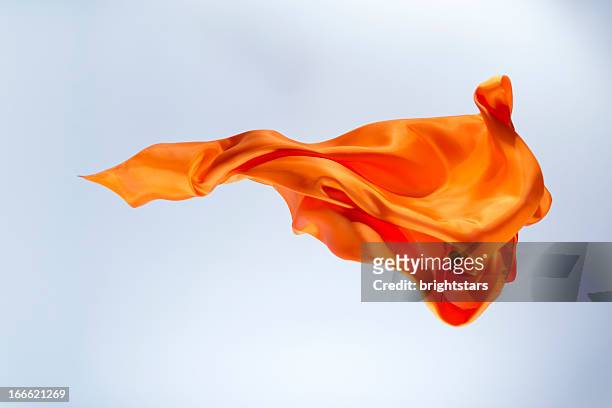 floating orange silk on a bright background - materiale tessile foto e immagini stock