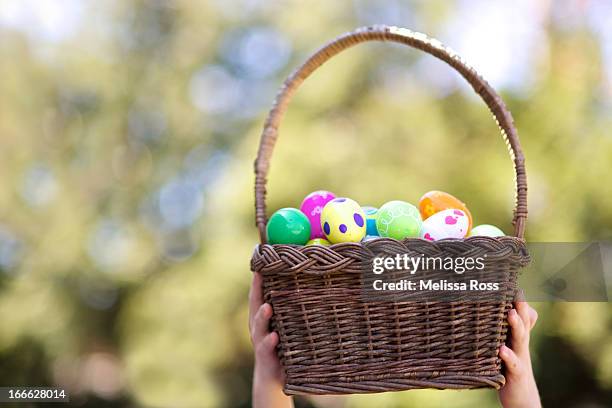 hands holding a basket full of easter eggs - easter eggs basket bildbanksfoton och bilder