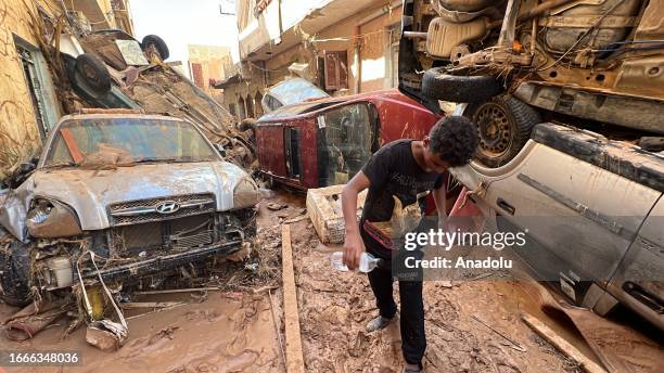 Child walks as cars damaged among buildings in the flood due to Storm Daniel in Derna, Libya on September 14, 2023.