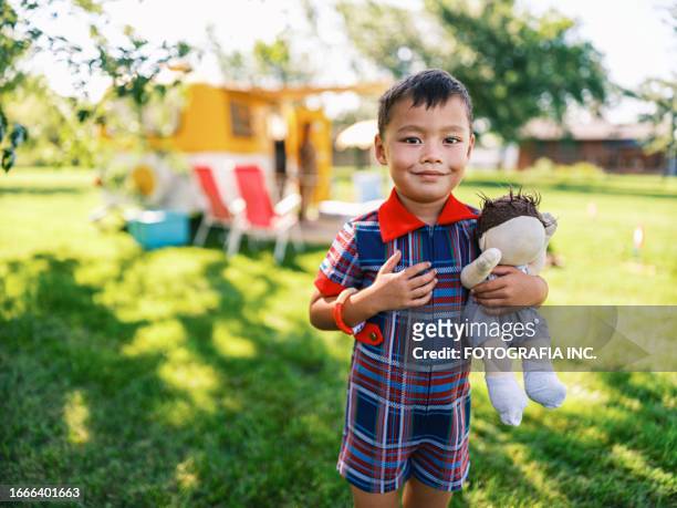 mixed race boy enjoying camping in summer - chinese dolls stock pictures, royalty-free photos & images