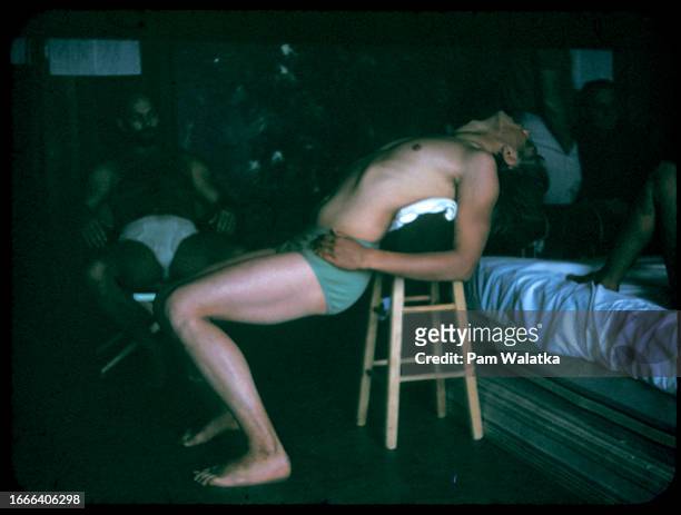 Esalen Resident Fellow Steve Stroud stretches over a stool during a Bioenergetics workshop at the Esalen Institute, Big Sur, California, 1967....