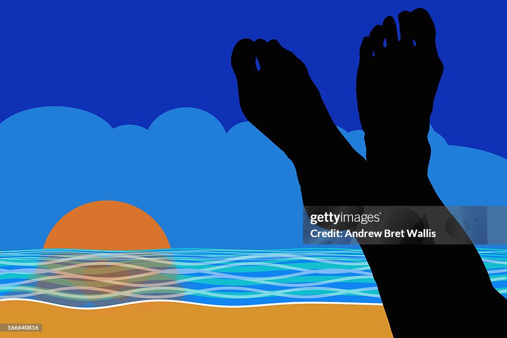 Silhouette of resting feet on a beach at sunset