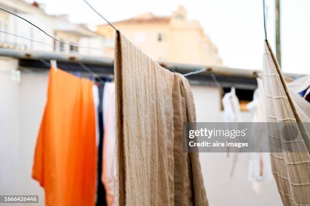 close up of clothes drying hanging on clothes line at sunny outdoors day - rainwater basin stock pictures, royalty-free photos & images