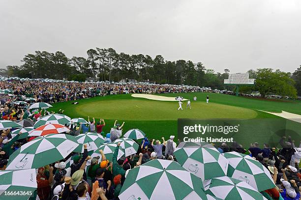 Adam Scott of Australia celebrates after making a birdie on the 18th hole in this handout image provided by the Augusta National Golf Club, during...