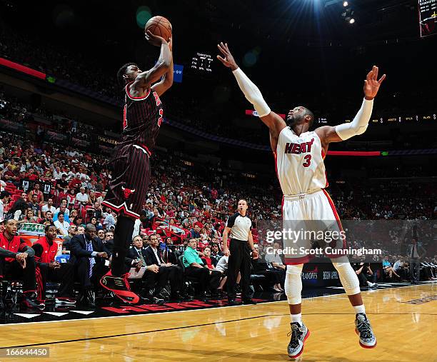 Jimmy Butler of the Chicago Bulls goes for a jump shot against Dwyane Wade of the Miami Heat during a game between the Chicago Bulls and the Miami...
