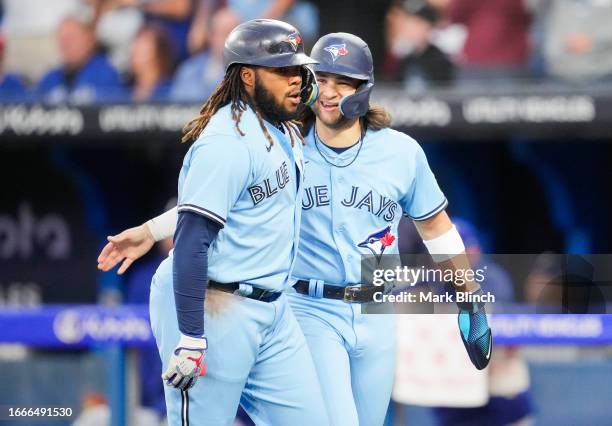 Vladimir Guerrero Jr. #27 of the Toronto Blue Jays celebrates his two-run home run with Bo Bichette in the first inning against the Texas Rangers at...