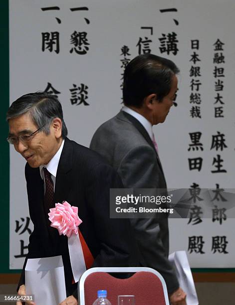 Haruhiko Kuroda, governor of the Bank of Japan , left, bows as Taro Aso, Japan's deputy prime minister and finance minister, leaves the annual...