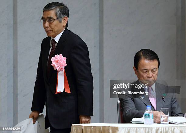 Haruhiko Kuroda, governor of the Bank of Japan , left, walks past Taro Aso, Japan's deputy prime minister and finance minister, as he walks to the...