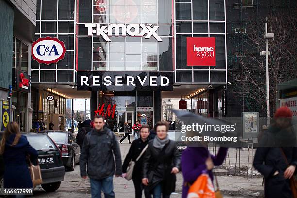 Pedestrians pass a shopping mall advertising TK Maxx, C&A and Home&You brands in Warsaw, Poland, on Thursday, April 11, 2013. Poland's central bank...