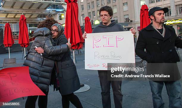 Sahar Zairab hugs Nova Browning Rutherford during a vigil at Yonge and Dundas square to mark the passing of bullying victim Rehtaeh Parsons.