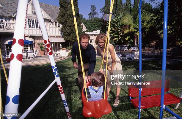 Actors John Travolta and Kelly Preston are photographed with son Jett for People Magazine in 1994 at home in Belair, California.