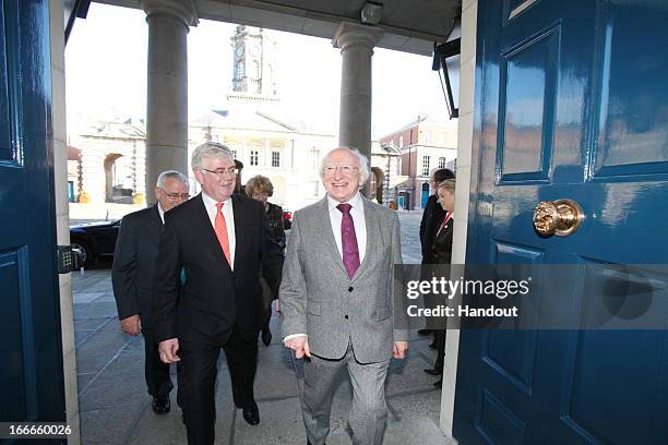 In this handout image provided by the Dept of the Taoiseach, President of Ireland, Michael D. Higgins is greeted by Tanaiste, Eamon Gilmore at the...