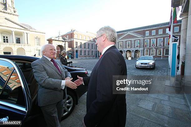 In this handout image provided by the Dept of the Taoiseach, President of Ireland, Michael D. Higgins is greeted by Tanaiste, Eamon Gilmore at the...