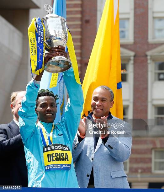 Lelisa Desisa Benti of Ethiopia holds the trophy after winning the men’s division of the 117th Boston Marathon as Duval Patrick, governor of...