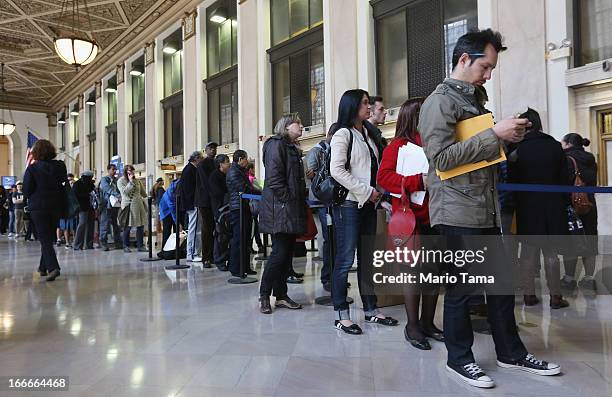 People wait in line inside the James A. Farley post office building April 15, 2013 in the Manhattan borough of New York City. With the U.S. Tax...