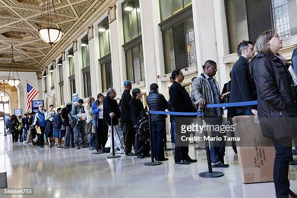 People wait in line inside the James A. Farley post office building April 15, 2013 in the Manhattan borough of New York City. With the U.S. Tax...
