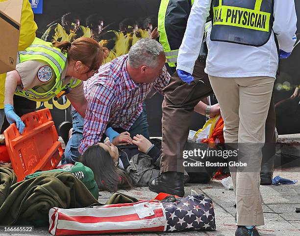 Emergency personnel respond to the scene after two explosions went off near the finish line of the 117th Boston Marathon on April 15, 2013.