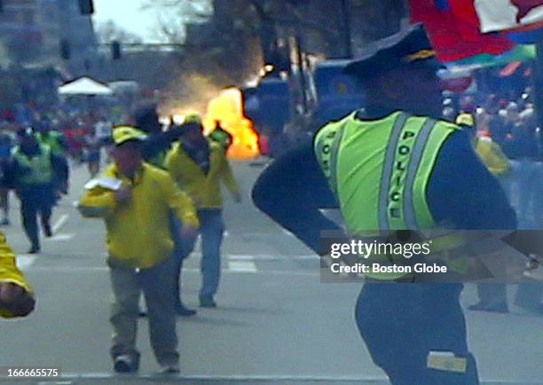 Second explosion goes off as a runner was blown to the ground by the first explosion near the finish line of the 117th Boston Marathon.