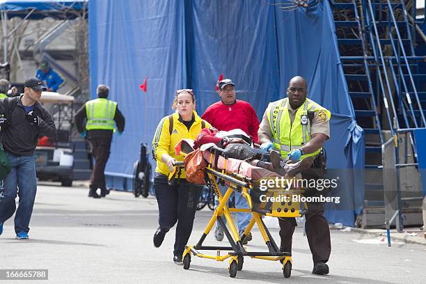 First responders transport the wounded where two explosions occurred along the final stretch of the Boston Marathon on Boylston Street in Boston,...