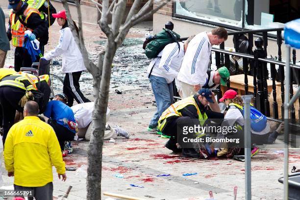 First responders rush to help injured people after two explosions occurred along the final stretch of the Boston Marathon on Boylston Street in...