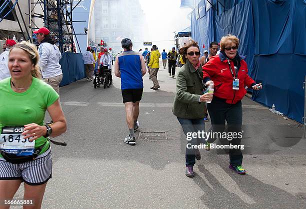 Runners and spectators flee from the scene where two explosions occurred along the final stretch of the Boston Marathon on Boylston Street in Boston,...