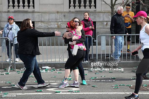 Runner embraces another woman on the marathon route near Kenmore Square after two bombs exploded during the 117th Boston Marathon on April 15, 2013...