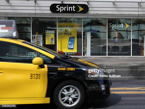 Taxi drives by a Sprint store on April 15, 2013 in San Francisco, California. Dish Network Corp has offered to purchase Sprint Nextel Corp for $25.5...